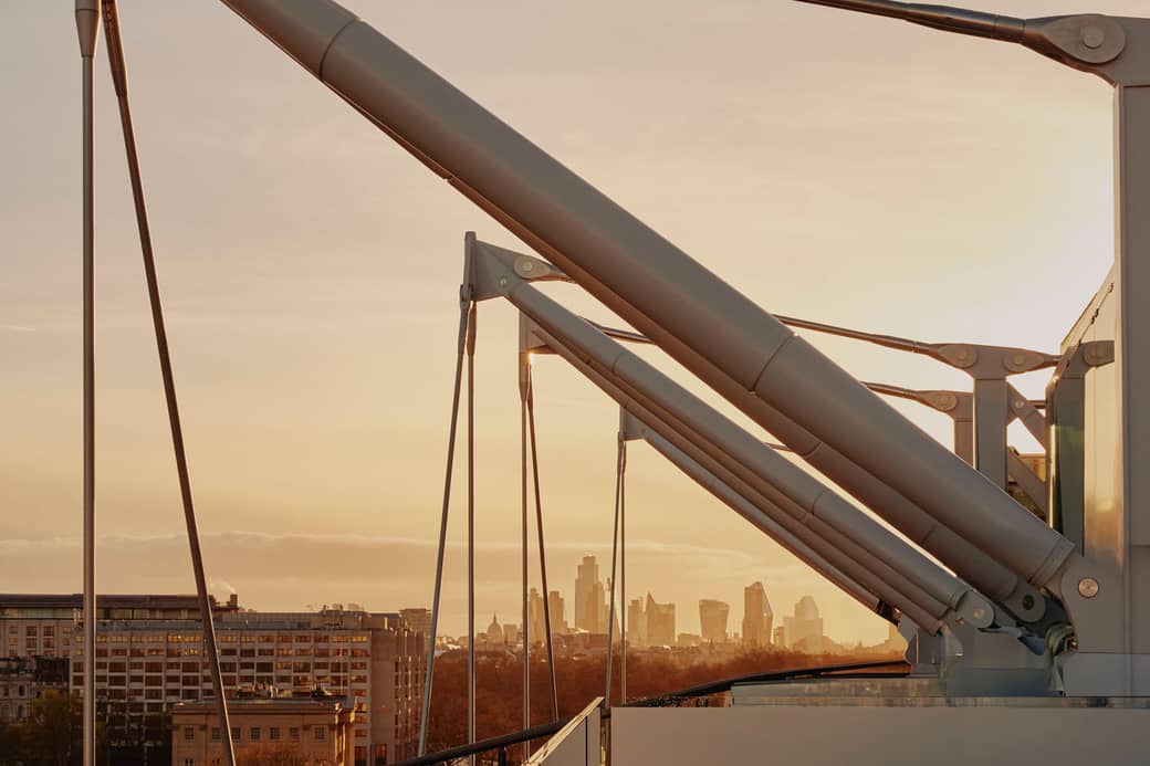 Sunlit urban skyline framed by modern architectural details, blending precision engineering with a warm cityscape glow.